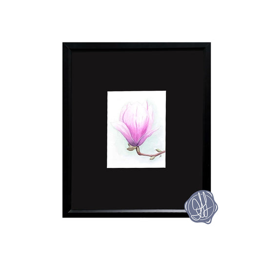 Framed watercolor painting of a single magnolia bloom on a stem against a soft green background.